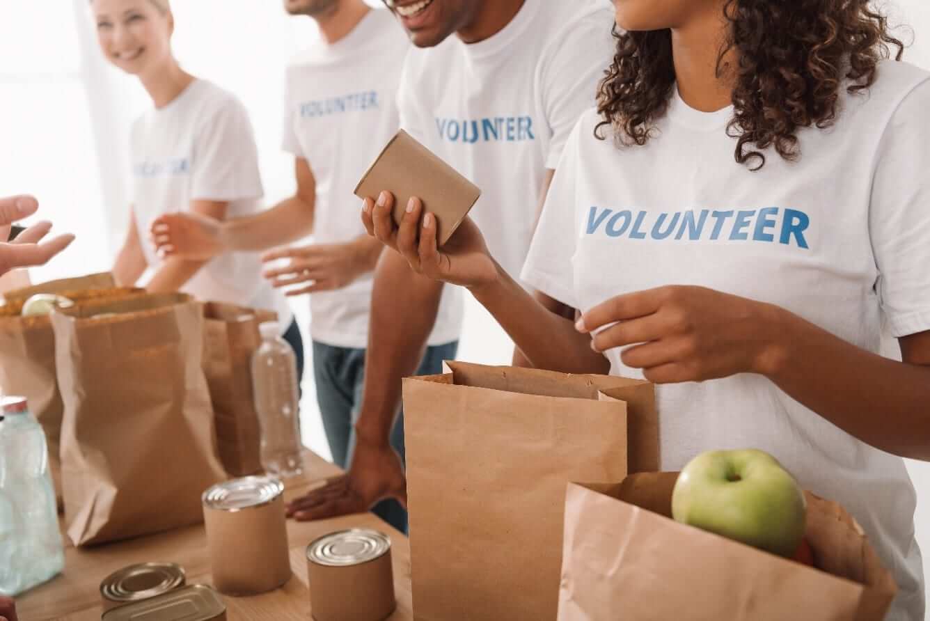 People packing groceries into paper bags